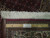 Ruler and authentic Persian hand knotted label placed across the white fringe end of rug