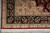 Corner of the hand-knotted rug with sage spandrel, black floral border and red selvedge