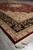 Angled corner view of the formal Persian rug on tile with full ivory fringe