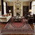 Formal living room styled with the red Kashan rug, cream sofa, leather chairs and crystal chandelier