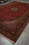 Large 9'6" x 15' Kashan rug seen from the corner with deep red floral field