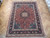 8'6" x 11'6" wool area rug on parquet floor, burgundy field and midnight navy border