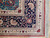Corner detail showing ivory diamond guard stripe, navy floral border and hand-tied cotton fringe