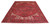 Angled floor view of a red hand-knotted Heriz wool rug showing full geometric medallion layout
