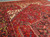 Close-up of ivory spandrel and navy turtle border detail on vintage Persian village wool rug