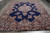 Vintage 10x13 Kerman rug photographed flat on grey floor showing medallion and broad floral border