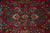 Close-up of hand-knotted wool pile with ivory palmettes and indigo leaves on crimson ground
