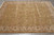 8'6" x 11'6" hand-knotted area rug flat on grey tile showing soft storage fold lines