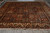 Angled full view of semi-antique Persian rug showing ivory cypress border and terracotta compartments