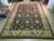 Angled view of black and ivory 12x18 hand-knotted wool rug with wide floral border
