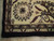 Corner detail with ivory border rosette, burgundy leaves and hand-tied fringe on wool rug