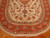 Close view of ivory field showing blue palmettes, green leaves and rust vine scroll border
