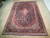 10'3" x 14'6" Persian Kashan rug displayed on light wood floor showing full floral field