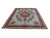 Light turquoise Tabriz rug photographed at an angle showing rose medallion and crimson floral border
