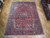 9x12 Persian Heriz wool rug shown full length with navy palmettes and rosette border