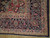 Corner detail showing ivory guard stripes, navy main border, rosettes and hand-tied wool fringe