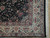 Corner detail of ivory main border, slate blue guard stripes and clean cotton fringe