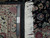 Back of the 9x13 rug beside a ruler, tight knot rows and hand knotted tag