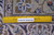 Back of hand-knotted wool Kashan rug with ruler confirming authentic handmade knot density