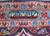 Woven signature cartouche in Persian script framed by blue and ivory border rosettes