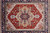 Hand-knotted 9x12 Oriental rug seen from above, red field inside deep navy main border