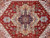 Close detail of navy medallion core, camel star outline and salmon blossoms on red pile
