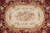 Close-up of ivory oval medallion with pink roses framed by golden acanthus leaf collar