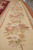 Border detail showing pink roses and magnolias on cream ground with rust brown outer band