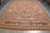 10x14 Aubusson flat weave rug seen at an angle with brown rose border and corner rosettes