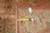 Back of the rug with tape measure, cotton fringe and original inventory tag visible