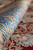 Rolled sky blue border curling over the red field, showing soft silky sheen and depth
