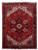 Deep red Persian Heriz rug with ivory spandrels, black border and geometric star medallion shown flat