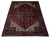 Red and blue 7x10 Heriz area rug photographed at an angle on a white floor