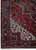 Corner detail with ivory spandrel scrollwork and indigo main border rosette motifs