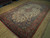 Angled floor view of the hand-knotted wool Tabriz rug, red border and blue corner spandrels