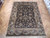 9' x 12'4" hand-knotted wool rug displayed on parquet floor showing navy field and ivory border