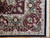 Corner detail with burgundy spandrel, green palmettes, pink rosettes and neatly finished side cord