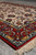 Low angle view across the ivory field and wine red border of this small Isfahan rug
