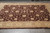 9x12 hand-knotted wool rug shown flat on grey tile, brown field with beige border