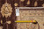 Rug back with tag reading size 9.3 x 11.10 beside a yellow tape measure