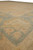 Low angle view across the sage green border and tan corner of the wool rug