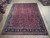 Hand-knotted wool rug laid flat on light wood floor showing all-over floral field