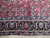 Woven signature cartouche in the navy border of this signed Persian Mashad wool rug