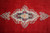 Close-up of ivory and navy center medallion with rose blossoms on open red Kerman field