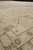 Close angled view of ivory main border with brown tribal motifs and low natural wool pile