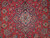 Close-up of ivory and navy floral medallion with palmettes on soft faded red wool field
