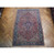 Traditional 6x10 Persian Heriz area rug photographed flat, red field with navy medallion center