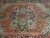Close-up of the navy and teal stepped medallion with ivory pendants on rust orange ground