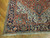 Corner detail showing navy border rosettes, ivory spandrel and hand-tied fringe of this Persian rug
