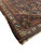 Corner detail showing ivory main border with hooked tribal devices over a brown wool ground
